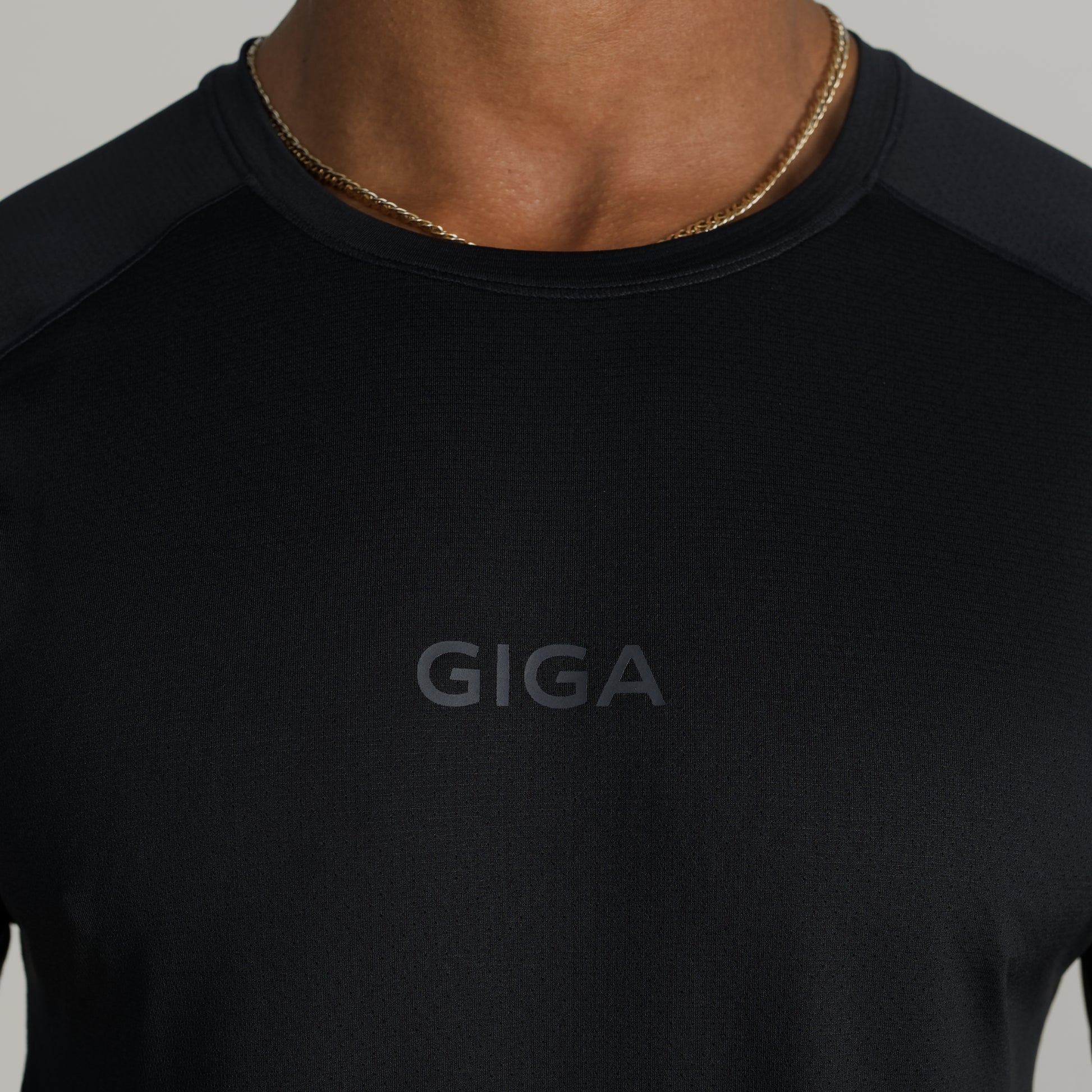 Close-up of GIGA logo on black Base Tee chest