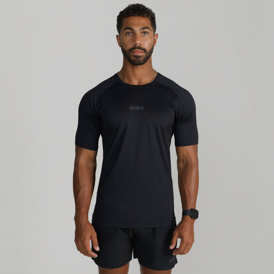 Male model wearing GIGA Base Tee in black, front view, slim fit athletic t-shirt