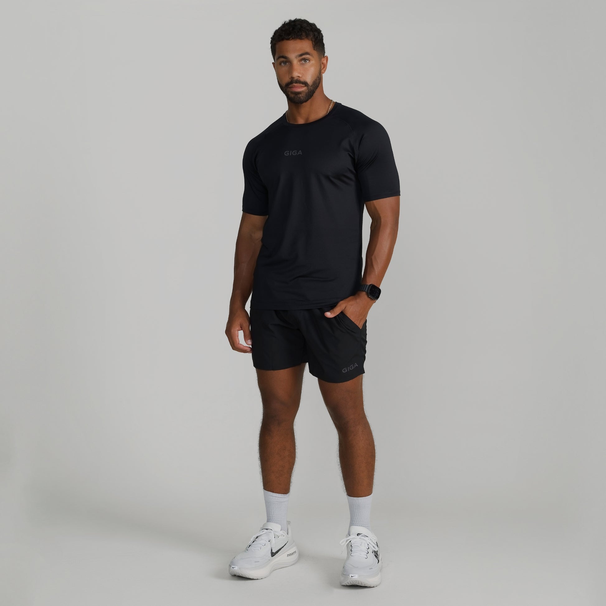 Male model wearing full GIGA outfit with black Base Tee and Train Shorts