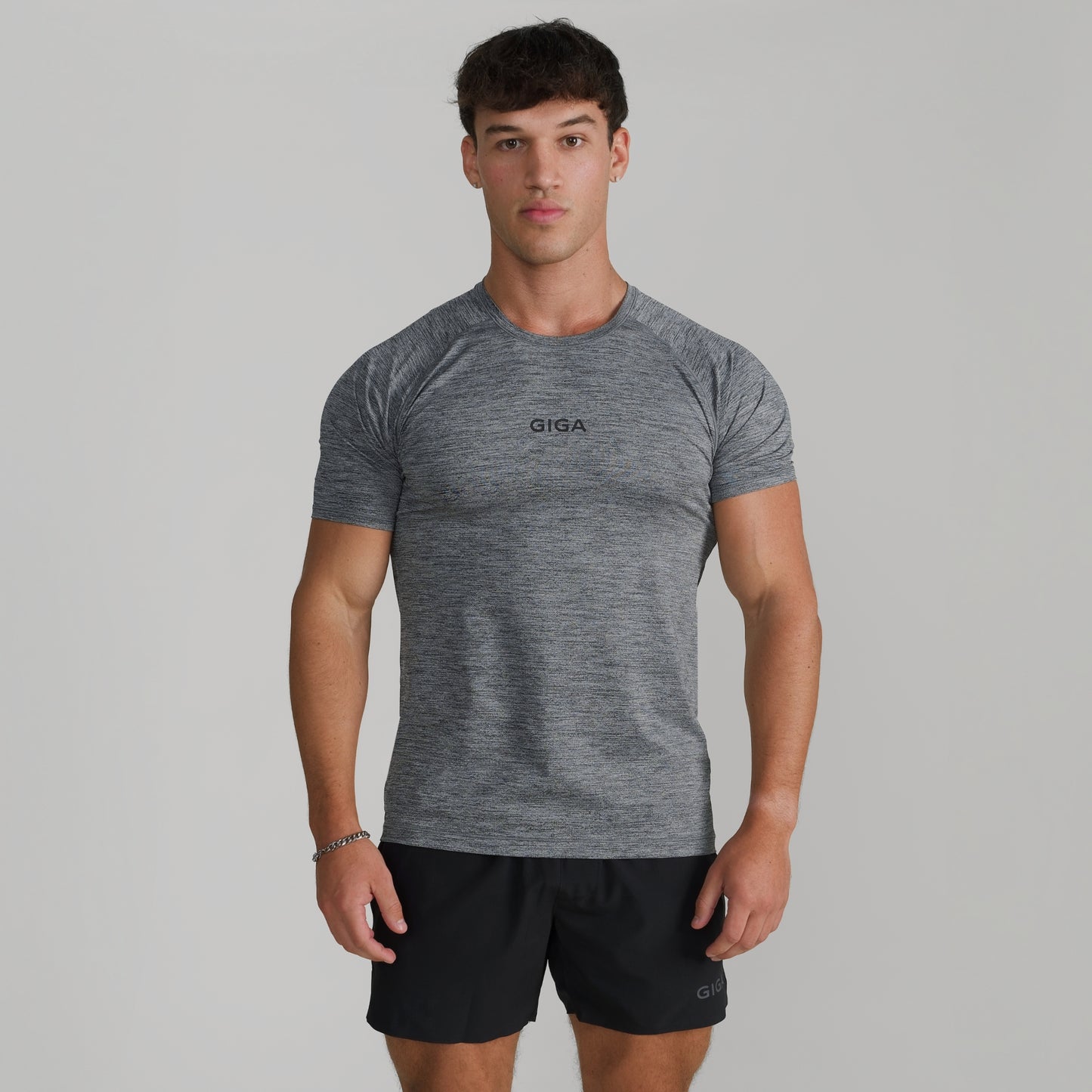 Male model wearing GIGA Base Tee in grey, front view, slim fit athletic t-shirt