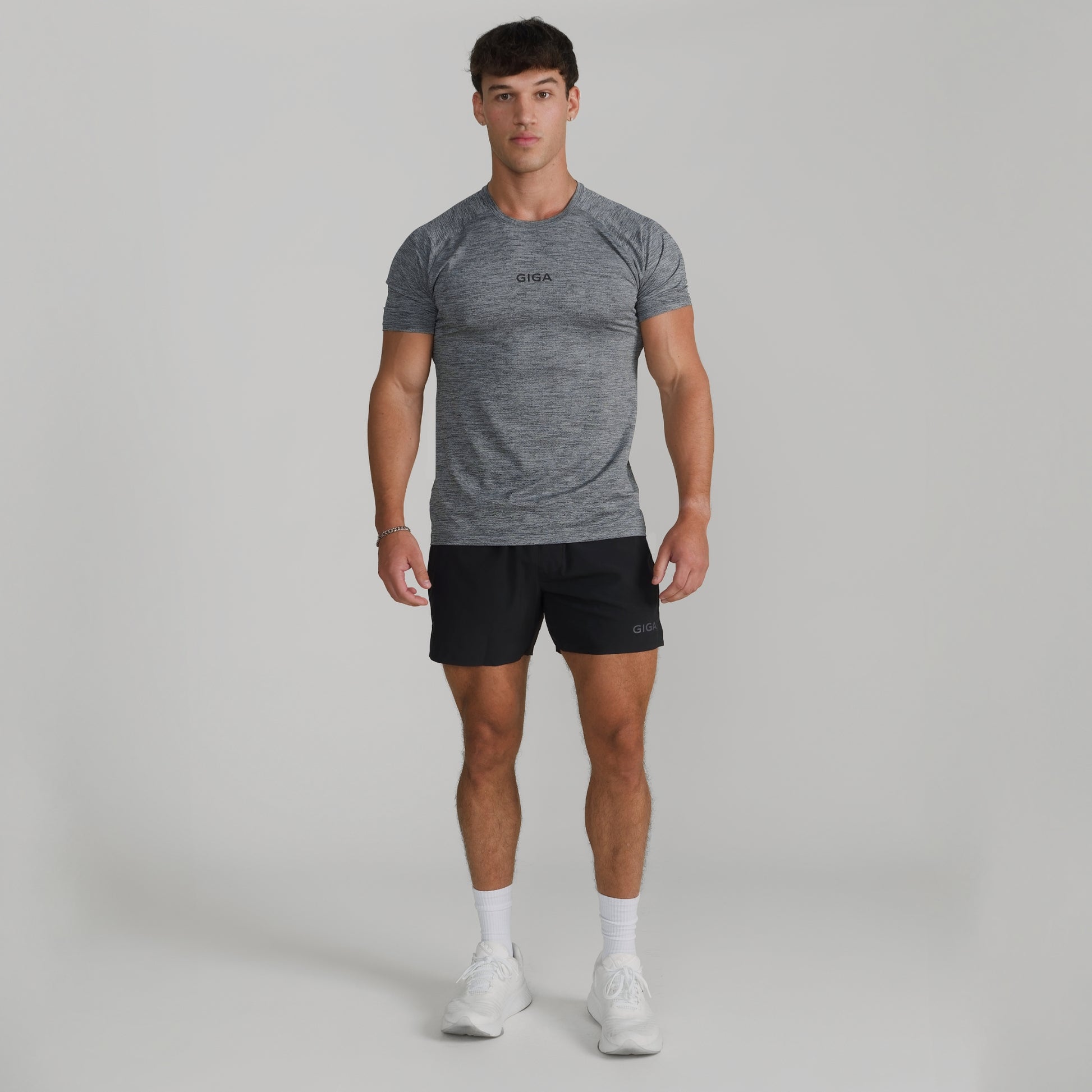 Male model wearing full GIGA outfit with grey Base Tee and black Train Shorts