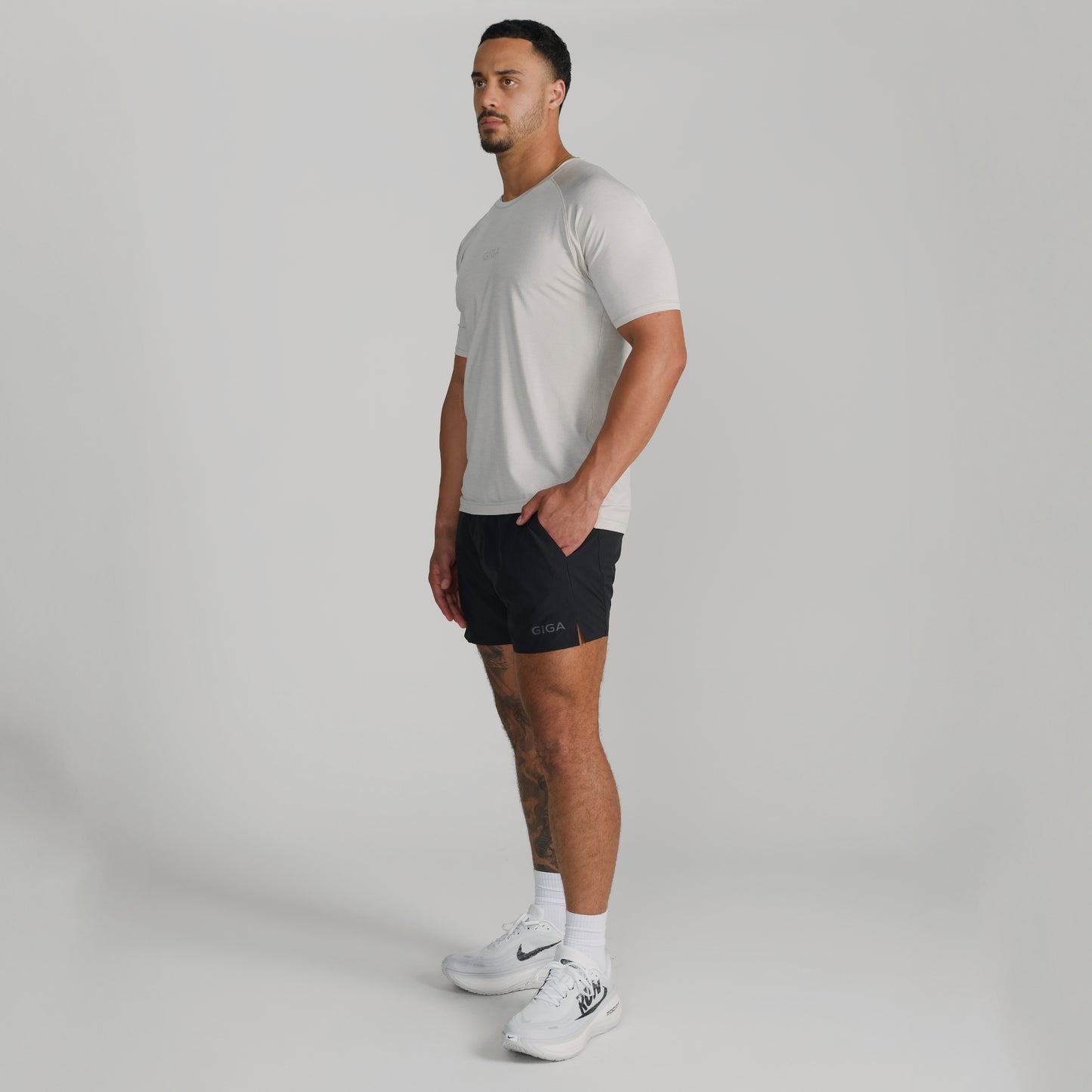 Male model wearing full GIGA outfit with white Base Tee and black Train Shorts
