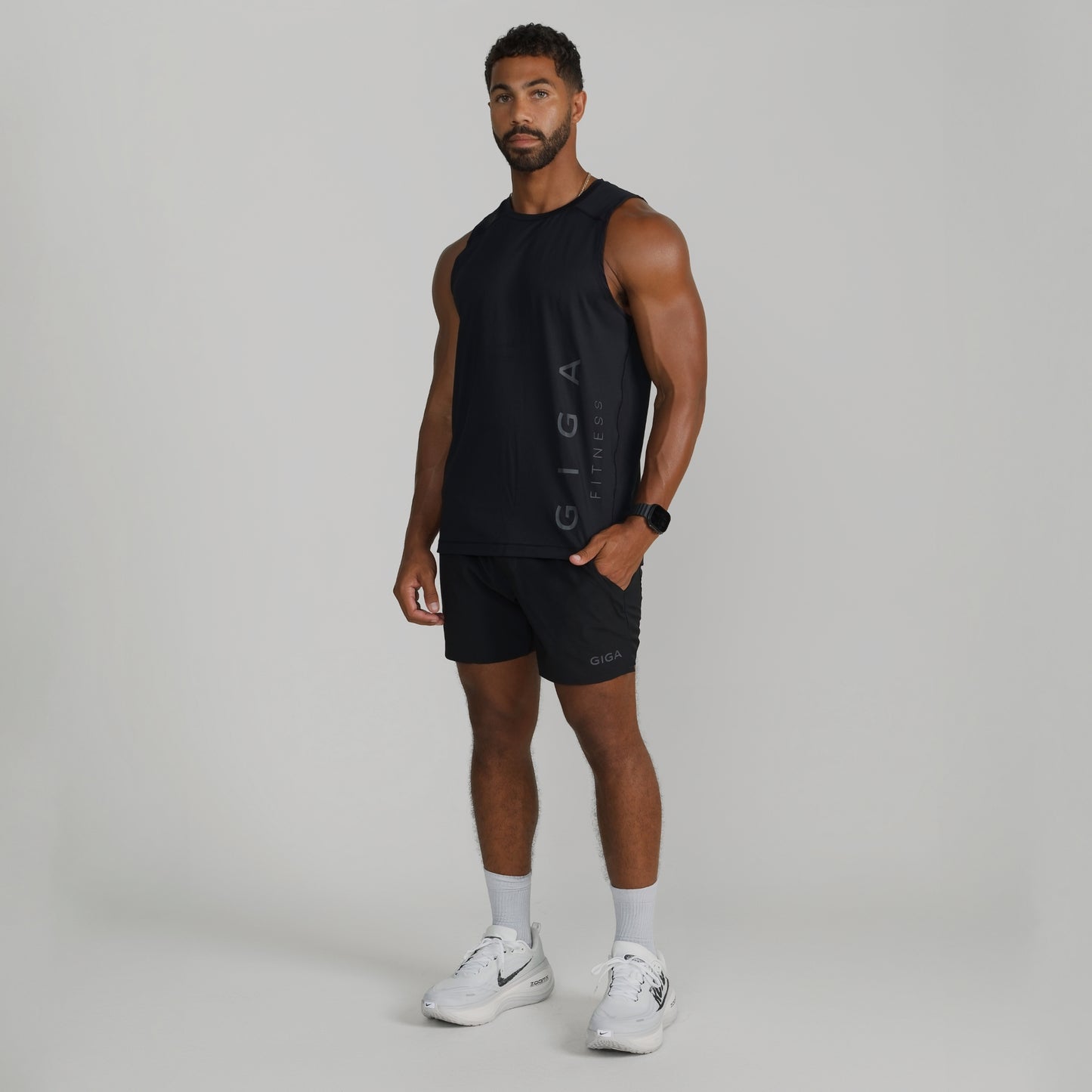 Male model wearing full GIGA outfit with black Core Tank and Train Shorts