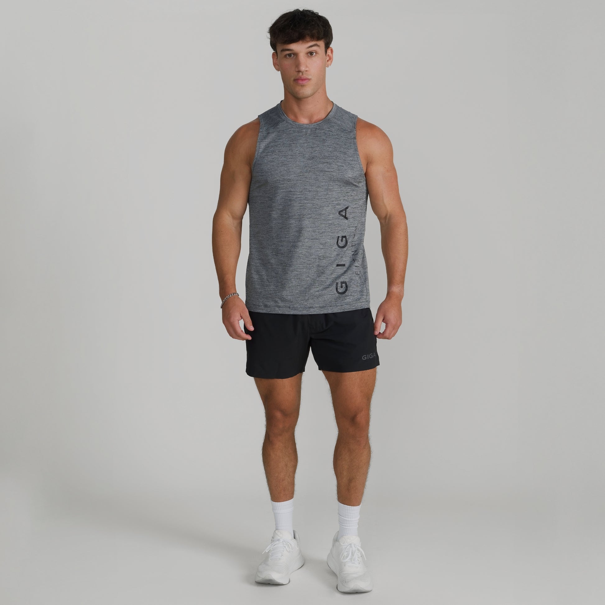 Male model wearing full GIGA outfit with grey Core Tank and black Train Shorts