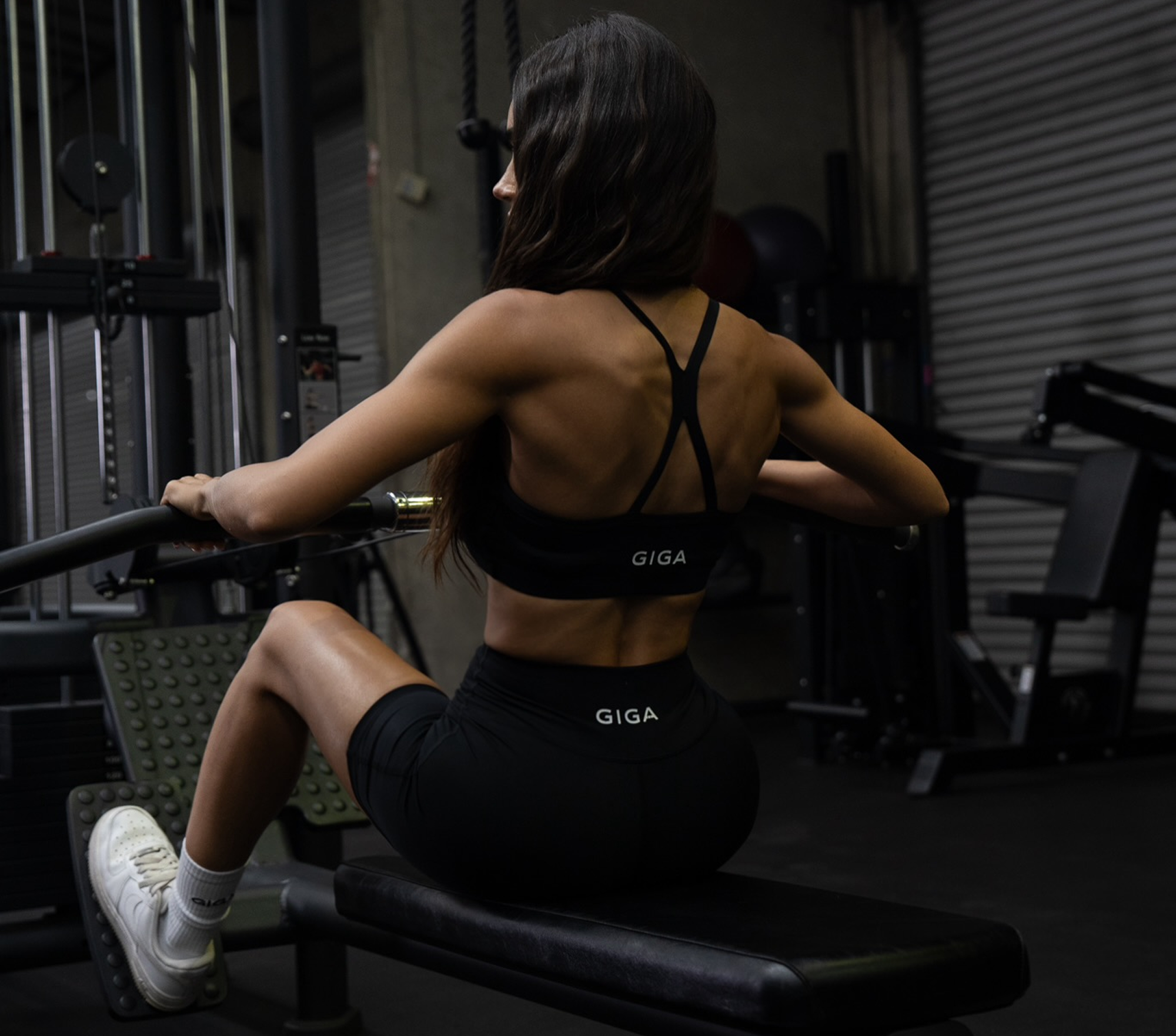 Woman performing seated row in gym wearing GIGA Freedom Bra and Control Shorts