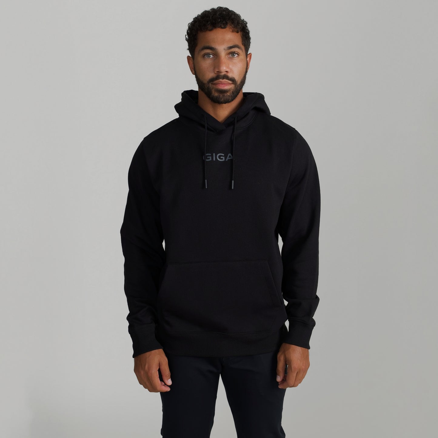 Man wearing GIGA Recovery Hoodie in black front view arms down upper body